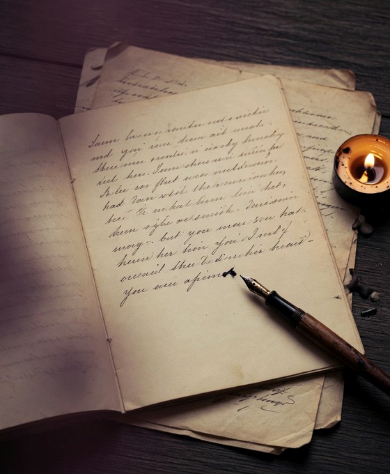 An unfinished handwritten journal with a pen resting beside it